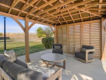 A wooden patio with a table and chairs at Lexington Park Apartments, Utah